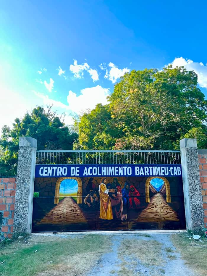 Portão principal do CAB pintado com a cena bíblica de Bartimeu, sob o letreiro com o nome do Centro